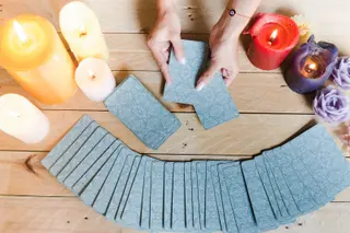 Fortune teller female hands and tarot cards on wooden table